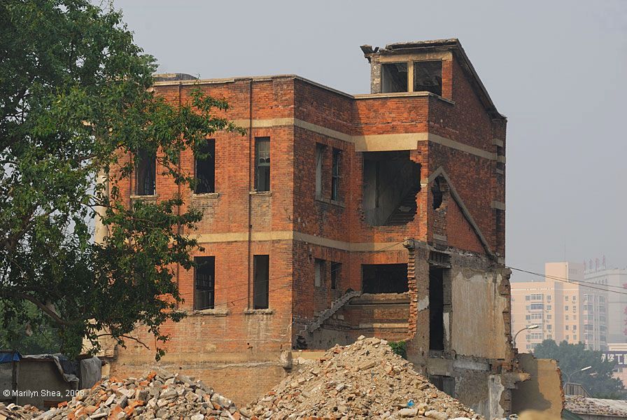 Western type brick building standing in the rubble of a block