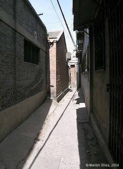 A narrow alley between walls of courtyards