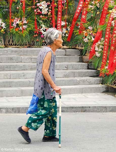 Woman walking past Qian Xiang Yi silk shop