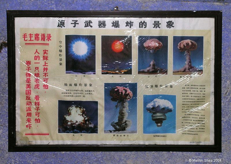 Poster showing atomic blasts and the American threat