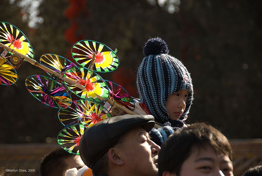 Boy on his father's shoulders holding a pinwheel