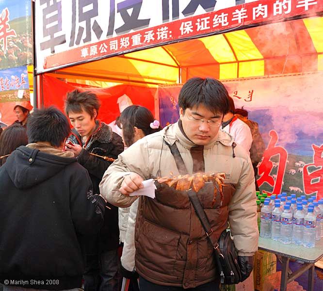 eating steaming squid on a stick