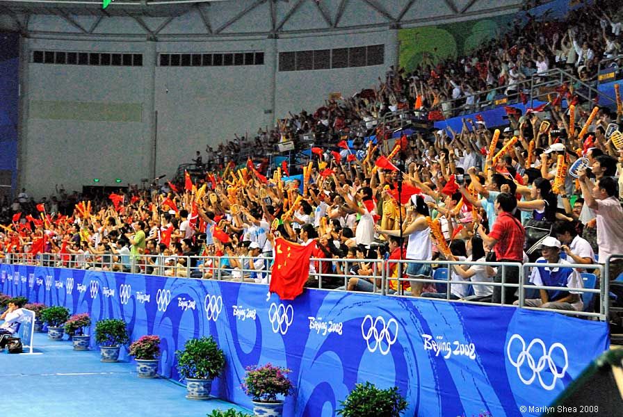 Crowd waving flags and orange sticks