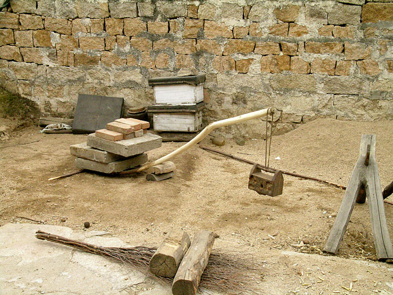 Broom and handle, bee hives in the background