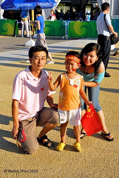 Friends and their son wearing an Olympic headband making the peace sign