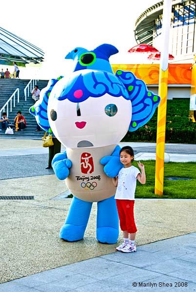 little girls with blue fish Fuwu mascot of the Olympics
